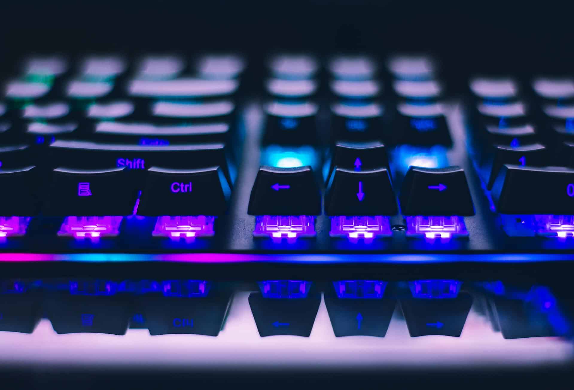 Backlit gaming keyboard with blue and purple LED lighting for professional office and gaming setups.