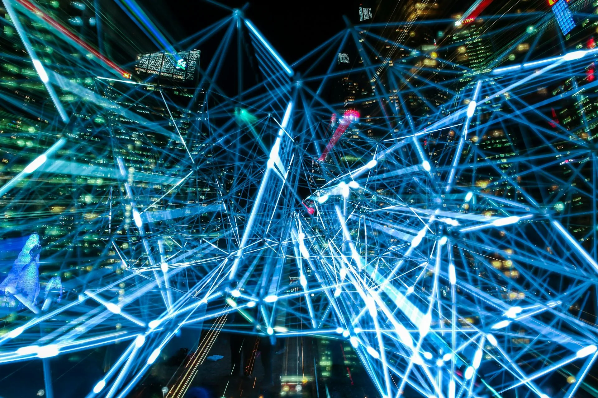 Futuristic digital network with connecting lines and city skyline, representing AI office development and smart technology solutions. Bright blue light lines forming a complex digital web over a cityscape at night, symbolizing AI-driven office innovation and smart development.